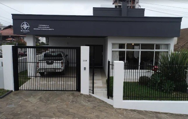 Fachada da sede da Eixo Sul Engenharia, com a placa Topografia, Agrimensura e Georreferenciamento